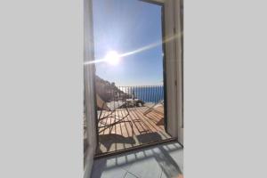 ein offenes Fenster mit Blick auf den Strand in der Unterkunft Celestina in Positano