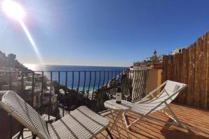 2 Stühle und ein Tisch auf einer Terrasse mit Meerblick in der Unterkunft Celestina in Positano