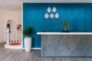 a blue wall with two potted plants on it at Mami Sabaudia Hotel in Sabaudia