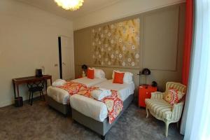 una camera d'albergo con due letti e una sedia di Grand Hotel Bellevue - Grand Place a Lille