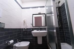 a bathroom with a sink and a toilet and a mirror at PC Boutique H Napoli Centro, by ClaPa Group in Naples