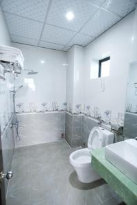 a bathroom with a toilet and a shower and a sink at Truong An Hotel in Vung Tau