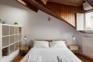 - une chambre avec un lit blanc et des plafonds en bois dans l'établissement Modern and Elegant studio apt - Milano Isola District, à Milan