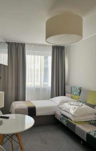 1 dormitorio con 2 camas, mesa y lámpara en Ośrodek Delfin Rewita, en Jurata