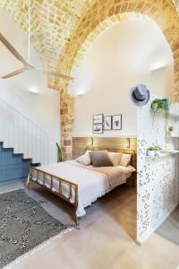 a bedroom with a bed and a brick wall at Melisende in Acre