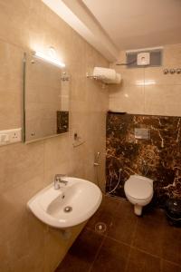 a bathroom with a sink and a toilet at Gopuram Residency in Madurai