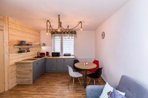 eine Küche mit einem Tisch und eine kleine Küche mit einem Sofa in der Unterkunft Apartament Hanki przy Krupówkach in Zakopane