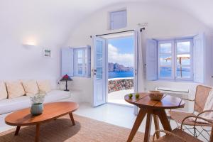 a living room with a couch and a table at Pezoules of Oia in Oia