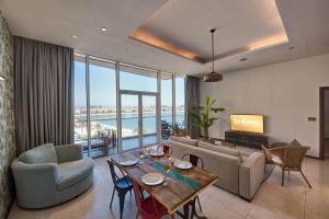 a living room with a couch and a table at bnbmehomes - Private Beach, Infinity Pool, Beach Club at Andaaz -204 in Dubai