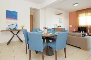 a dining room with a table and blue chairs at Villa Madison in Protaras