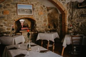 a dining room with two tables with white tablecloths at Antico Borgo Seggiano in Seggiano