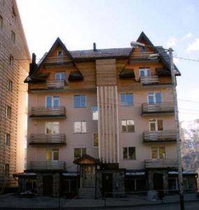 a large apartment building with a gambrel roof at Marco Polo, Mountain View Apartment in Gudauri