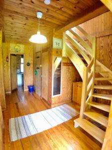 a room with a wooden staircase in a cabin at Pod lipą in Ruciane-Nida