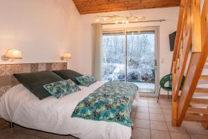 a bedroom with a bed and a large window at "La Combe Fleurie" Appartements & Chambres in Saint-Bonnet-en-Champsaur