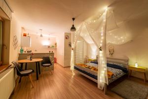 a bedroom with a canopy bed and a table at Dragonfly Studio with GARDEN in Braşov