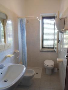 bagno bianco con lavandino e servizi igienici di Residenza Altmar a Briatico
