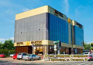 un gran edificio con coches estacionados en un estacionamiento en Marton Severnaya Krasnodar, en Krasnodar