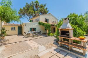 a backyard with a grill in front of a house at Casa de Campo con Encanto in Pollença