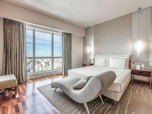 モスクワにあるスイスホテル クラースニエ ホールミのベッドと大きな窓が備わるホテルルームです。