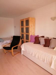 pokój z 2 łóżkami i krzesłem w obiekcie Casa Tavio 3 w Aronie
