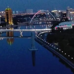 Апартаменты на набережной 15 этаж في أستانا: اطلاله على جسر فوق نهر في الليل
