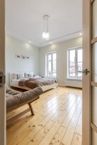 a bedroom with two beds and a wooden floor at InshiApartments on Grigorenko's square in Lviv