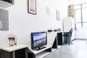 a room with a flat screen tv on a white wall at Stunning Maboneng Precinct Studio Apartment at 12 Decades Building in Johannesburg