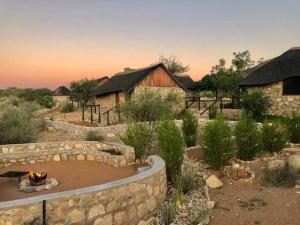 a garden with a fire pit and some buildings at Kapika Waterfall Lodge in Epupa