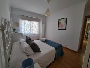 a bedroom with a bed with pillows and a window at Dos Torres Légolas - Ideal para Empresas con Parking Gratuito in Zaragoza
