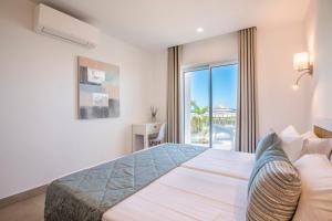 a bedroom with a large bed and a balcony at Clube Porto Mos - Sunplace Hotels & Beach Resort in Lagos