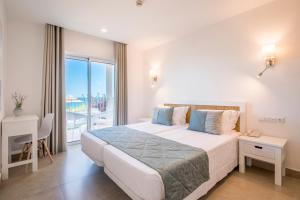 a bedroom with a large bed and a balcony at Clube Porto Mos - Sunplace Hotels & Beach Resort in Lagos
