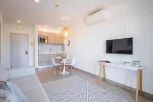 a living room with a table and a tv on a wall at Clube Porto Mos - Sunplace Hotels & Beach Resort in Lagos