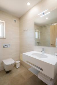 a white bathroom with a sink and a toilet at Clube Porto Mos - Sunplace Hotels & Beach Resort in Lagos