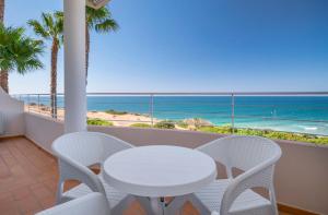 a white table and chairs on a balcony with the ocean at Clube Porto Mos - Sunplace Hotels & Beach Resort in Lagos