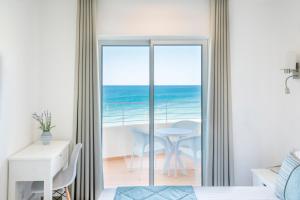 a bedroom with a view of the ocean at Clube Porto Mos - Sunplace Hotels & Beach Resort in Lagos
