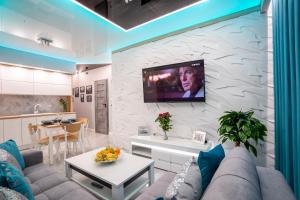 a living room with a couch and a tv on a wall at NEW Apartament VIP BLUE Warszawa+PARKING in Wola Mrokowska
