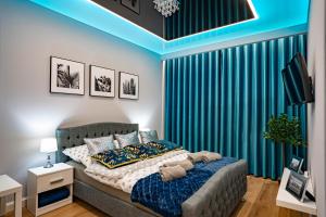 a bedroom with a bed and a blue curtain at NEW Apartament VIP BLUE Warszawa+PARKING in Wola Mrokowska