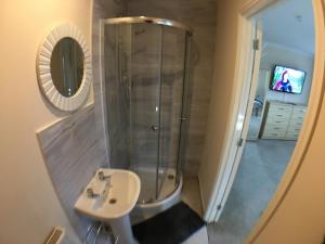 波士顿Very LARGE House, 6 beds, 4 bedrooms, 3 Bathrooms, 5 Smart TV's & VAN PARKING的带淋浴、水槽和镜子的浴室