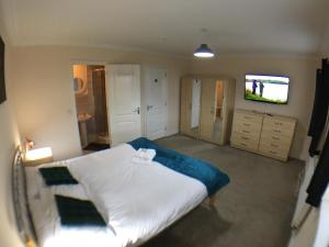 波士顿Very LARGE House, 6 beds, 4 bedrooms, 3 Bathrooms, 5 Smart TV's & VAN PARKING的一间带床和平板电视的卧室