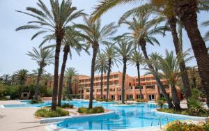 um resort com palmeiras e um edifício em El Ksar Resort & Thalasso em Sousse