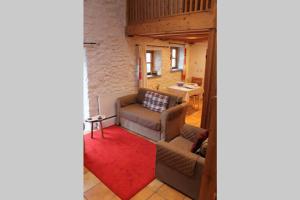 een woonkamer met een bank en een rood tapijt bij The Dairy @ Mill Haven Place in Haverfordwest