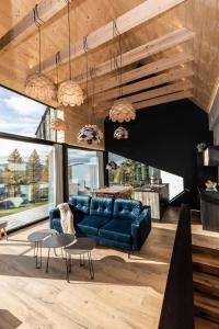 a living room with a blue couch and tables at udanypobyt OMG Houses in Kościelisko +96 photos