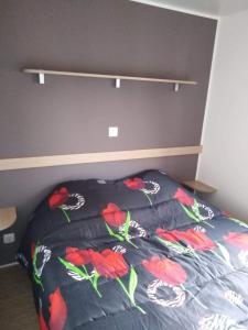 een slaapkamer met een bed met rode bloemen erop bij SABLE DU MIDI chez gégé in Valras-Plage