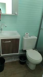 y baño con aseo blanco y lavamanos. en Férias na Barra da Lagoa, en Florianópolis