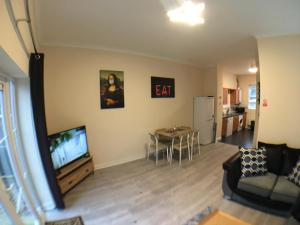 波士顿Very LARGE House, 6 beds, 4 bedrooms, 3 Bathrooms, 5 Smart TV's & VAN PARKING的带沙发、电视和桌子的客厅