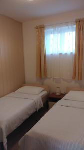 um quarto com 2 camas e uma janela com cortinas em Studio apartman Nina em Kraljevica