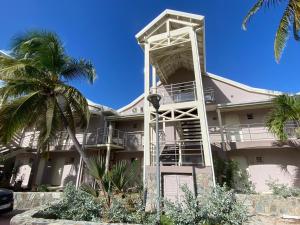 a white building with a ladder on the side of it at Orient Beach Hotel in Orient Bay