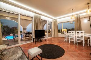 - un salon avec une télévision, une table et des chaises dans l'établissement Variza Residence, à Kypseli