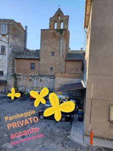 a parking lot with yellow flowers on a building at Appartamento Mia in Orvieto