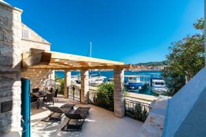eine Terrasse mit einem Tisch und Stühlen sowie einem Yachthafen in der Unterkunft Luxury Apartment Marina View No 1 in Vela Luka